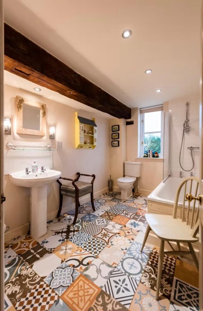 A large traditional bathroom with colourful tiles on the floor