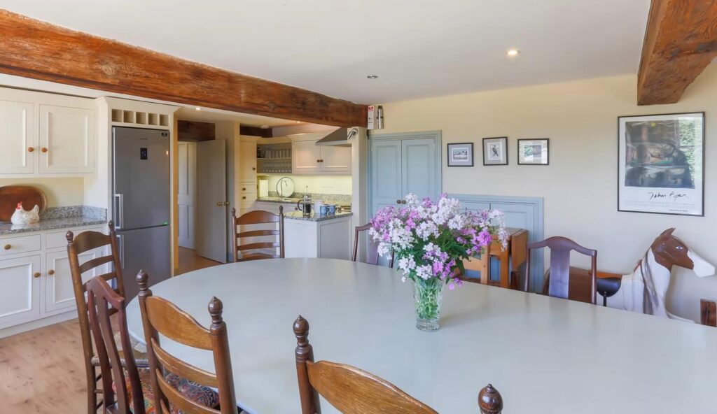 A country kitchen with a large table in the foreground