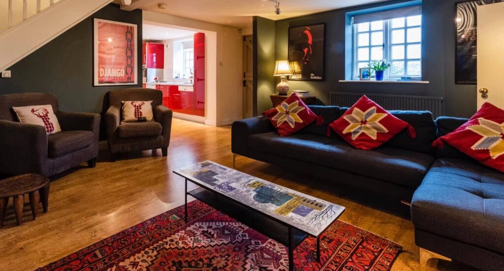A cosy snug room with dark blue sofas and armchairs